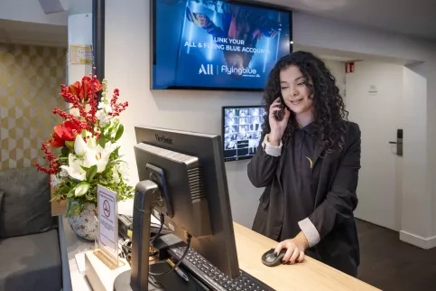 Un jeune fille au téléphone à la réception d'un hôtel 