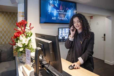 Un jeune fille au téléphone à la réception d'un hôtel