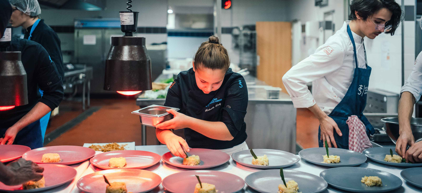 Plusieurs jeunes en train de préparer les plats en formation cuisine
